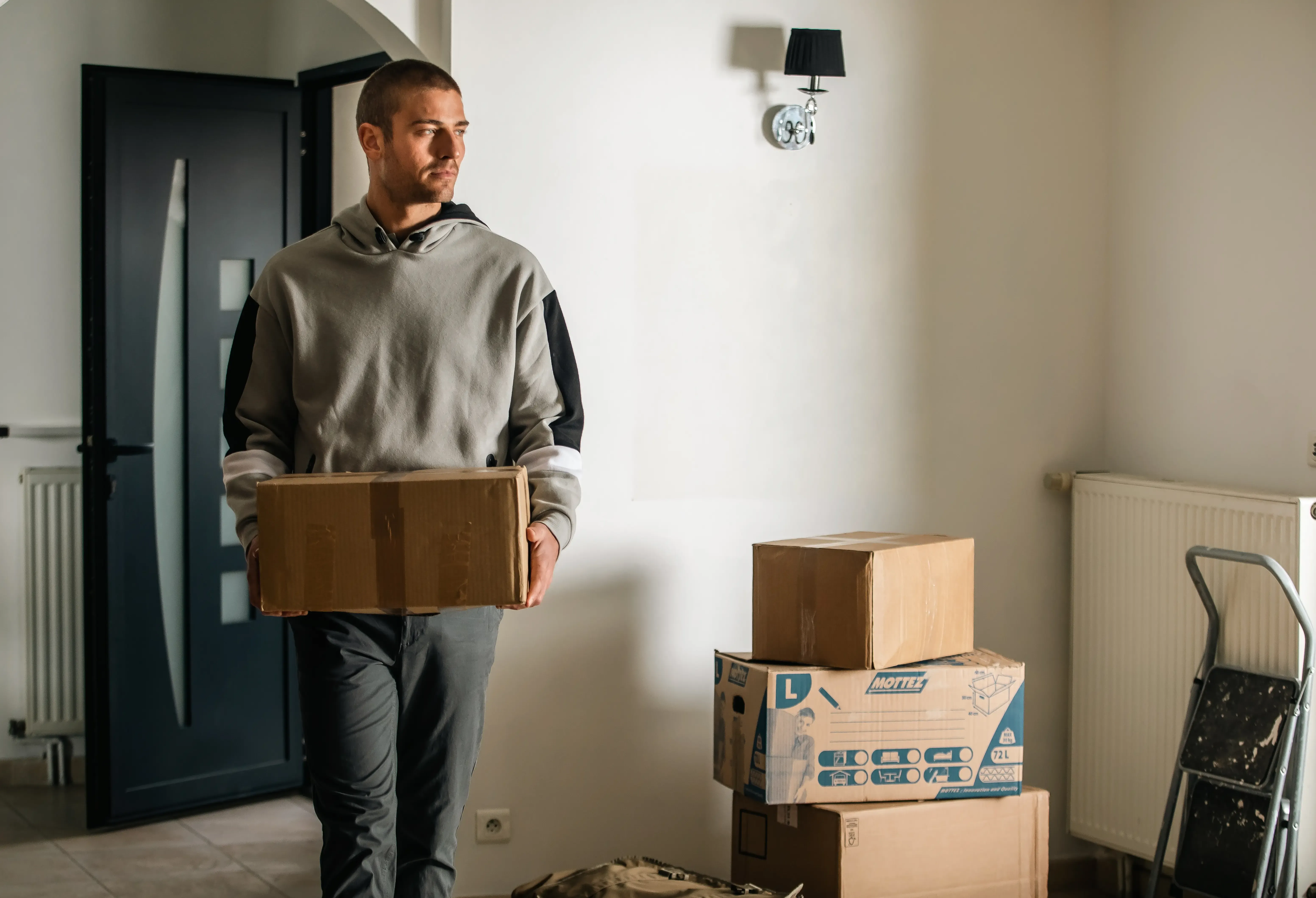 Homme qui porte des cartons pour aménager 