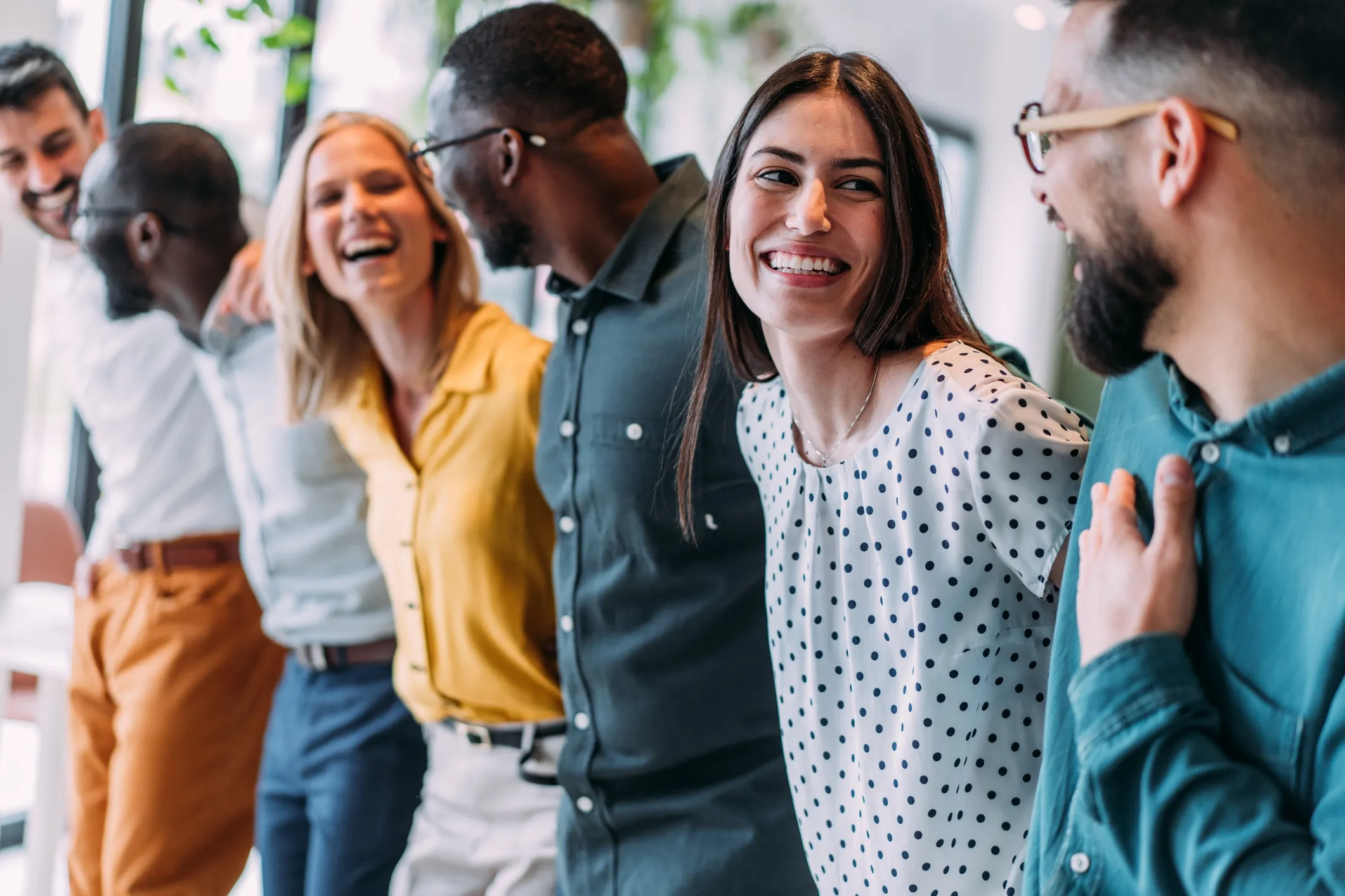 Collaborateurs échangeant dans une ambiance conviviale illustrant le bien-être, la cohésion et la diversité en entreprise