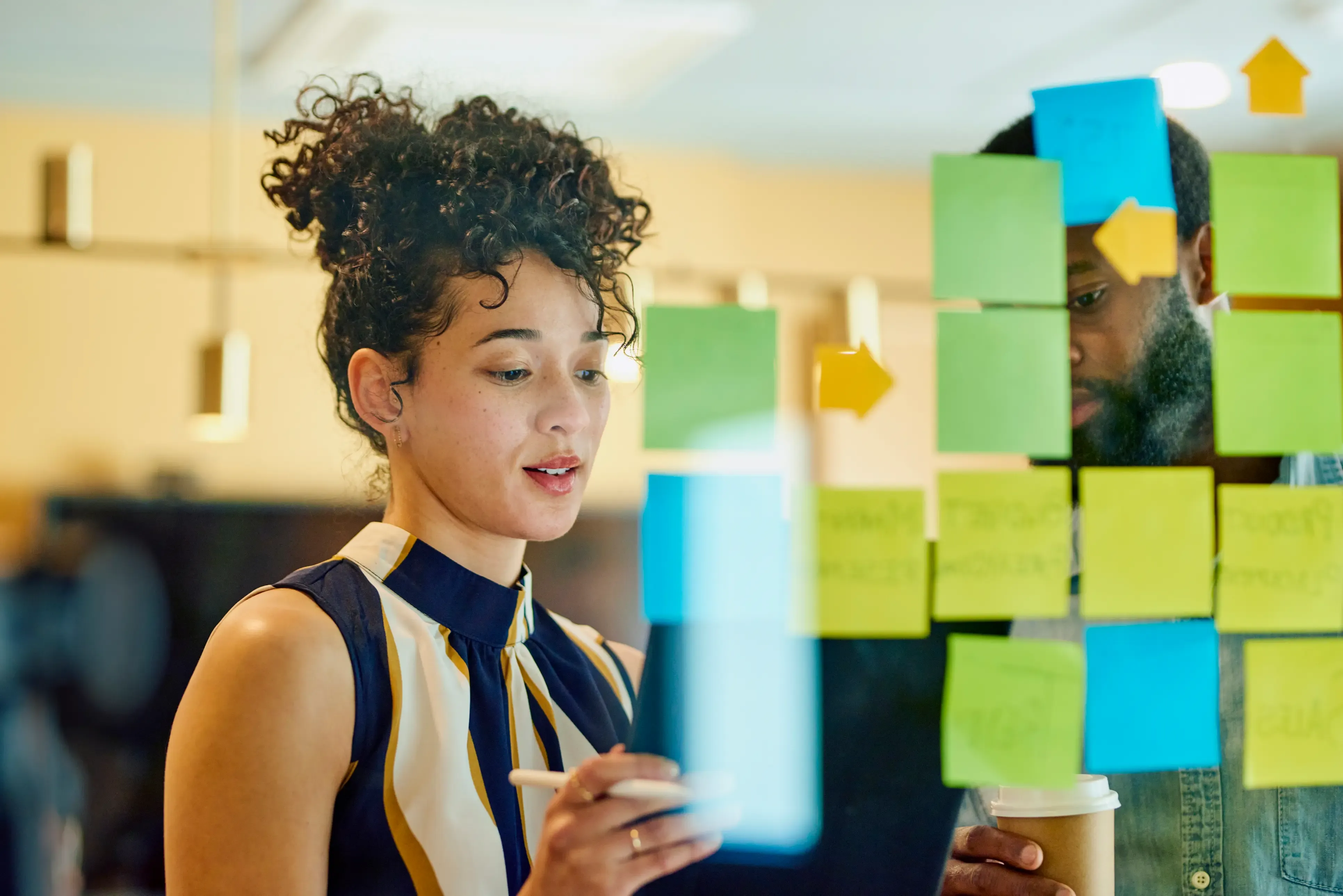 Collaboratrice travaillant sur un mur de post-it en mode agile