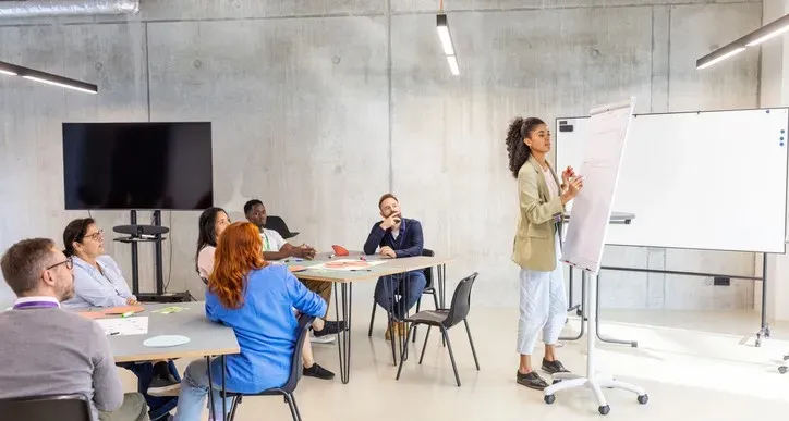 Formatrice animant une formation en entreprise devant un groupe de collaborateurs