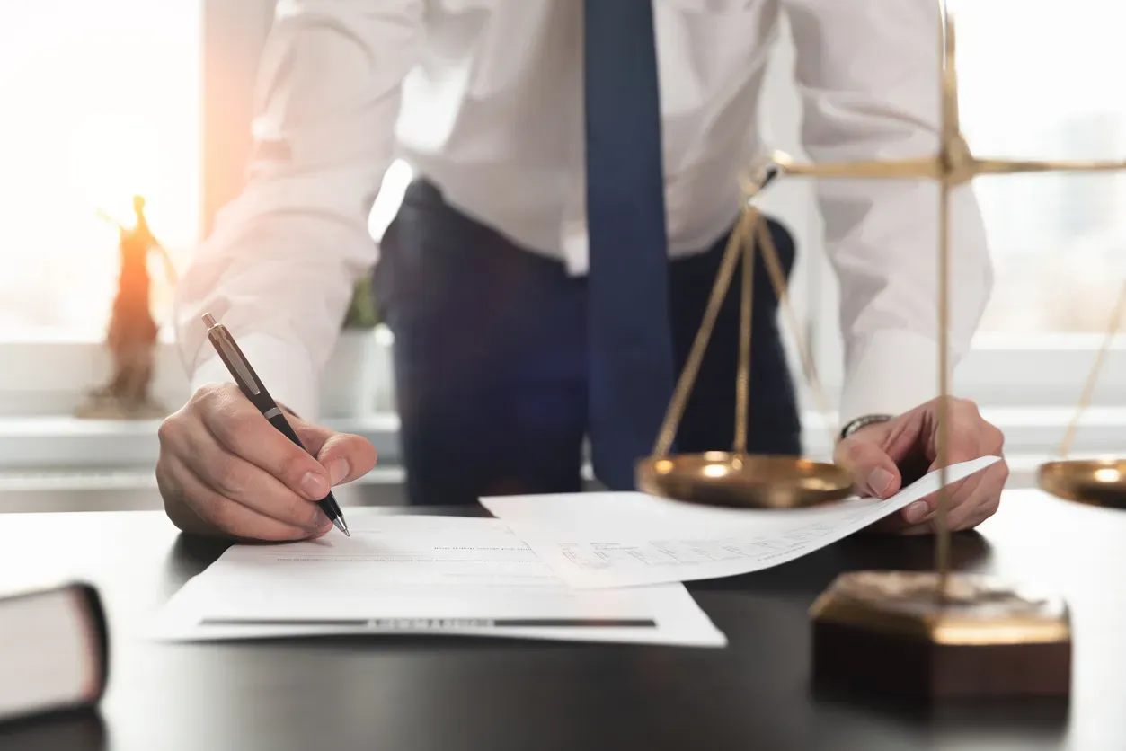 Personne signant un document juridique sur un bureau